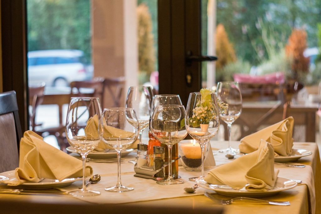 Table de restaurant joliment dressée, évoquant le tourisme gastronomique et œnologique en Sauternais, destination proposée par Assistance Taxi Sud-Gironde.