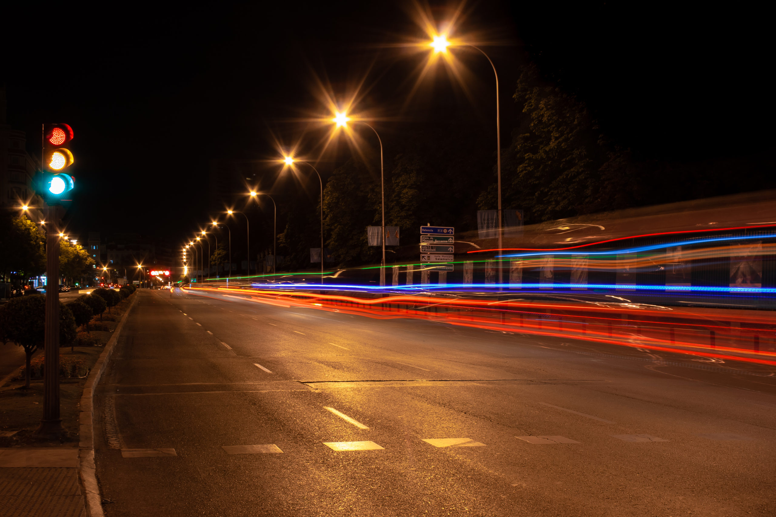 Une route éclairée de nuit avec un feu tricolore, connotant la réglementation suivie par votre taxi.